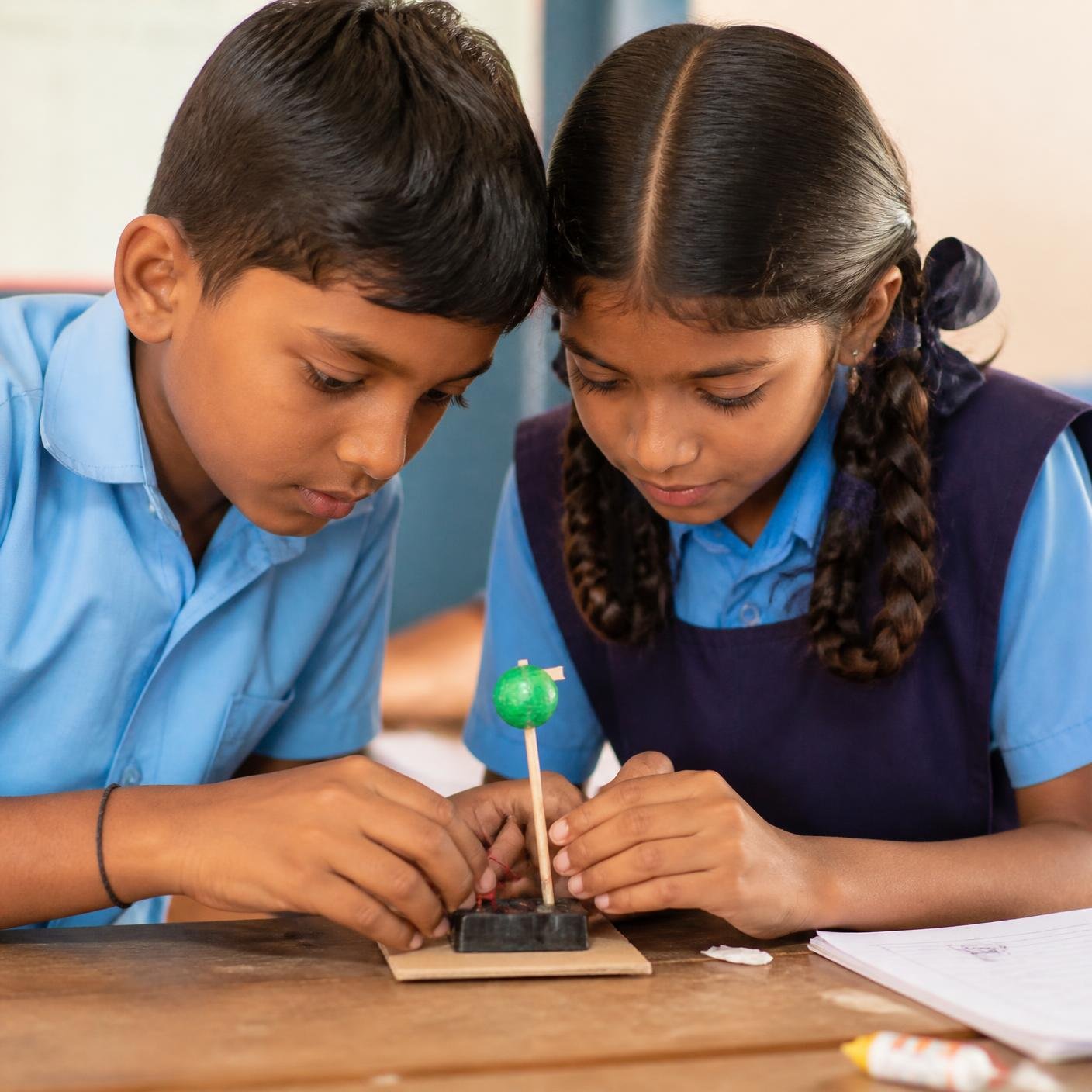Two students building a project together in class